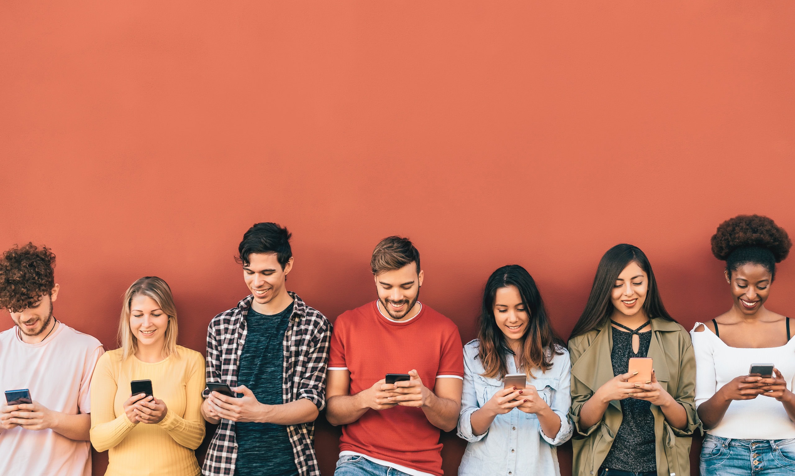 Group young people using mobile smartphone outdoor Millennial generation having fun with new trends social media apps Youth technology addicted Red background