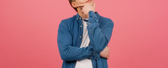 Portrait Thoughtful young man on pink background